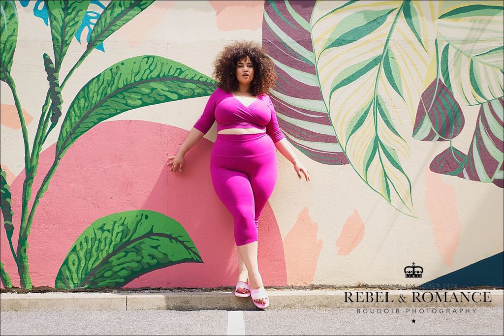 tropical photo shoot of plus size woman with afro wearing pink