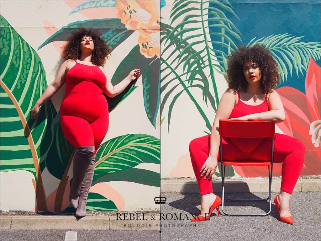 plus size woman in red posing in front of a tropical wall mural