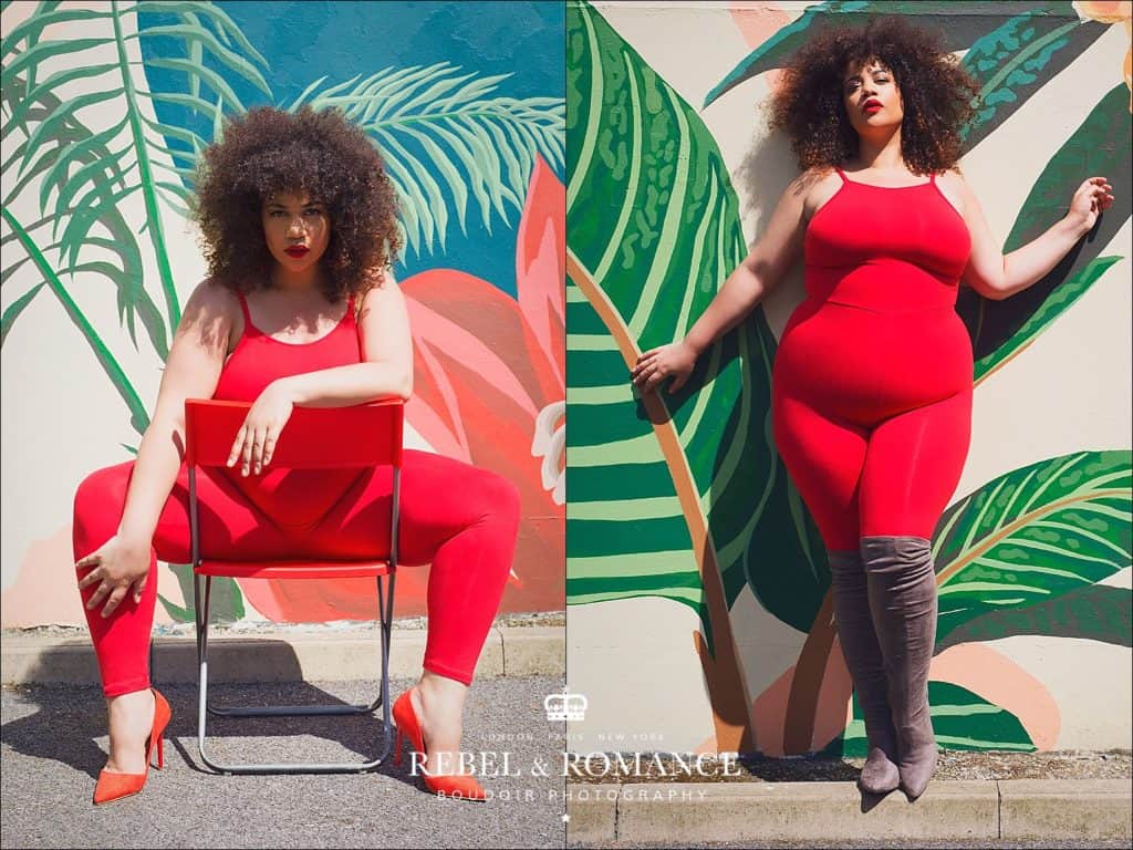 plus size woman in red jumpsuit posing in front of a tropical wall mural