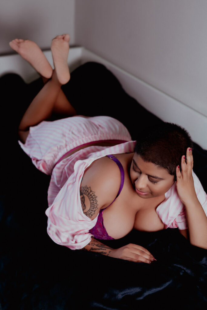 Boudoir photography in Suffolk, woman lying on day bed in pink pyjamas