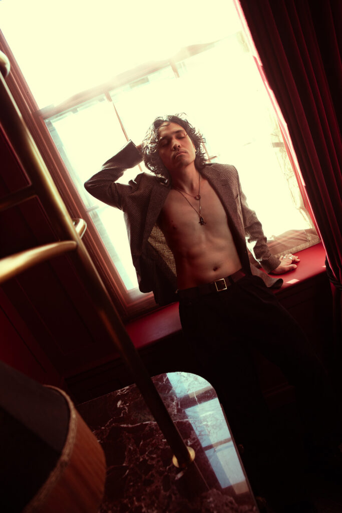 Andrew posing in the window, framed by backlight, editorial portrait London