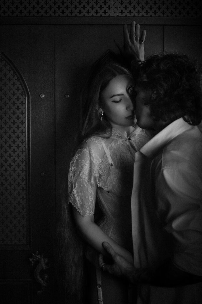 Couple kissing against a confessional, black and white moody feel, romantic London photoshoot