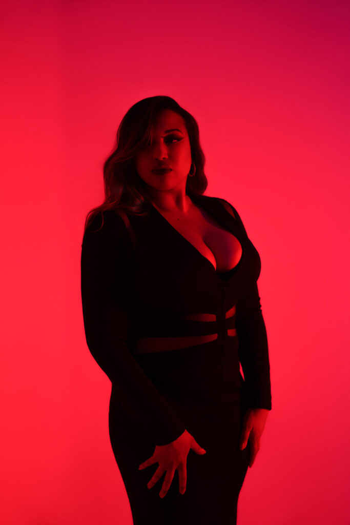 Boudoir portrait in London with curvy woman, moody red lighting, Lola bunny vibes
